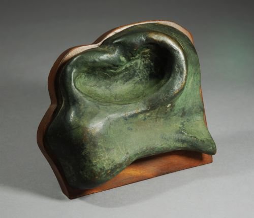fig 1. A patinated green bronze equestrian nostril fragment mounted on a contoured wooden base.