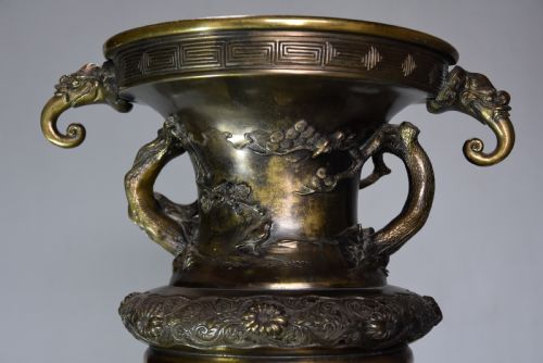 fig 1. A large 19th-century Japanese Meiji period patinated bronze vase with relief carvings of birds, dragon head handles, and decorative patterned borders.