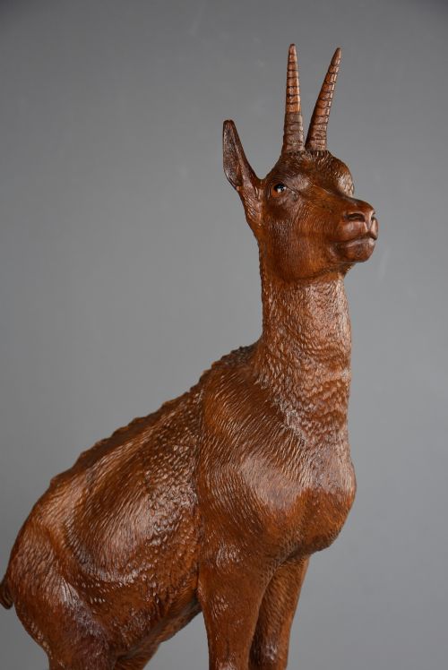 fig 1. A late nineteenth-century hand-carved linden wood sculpture of a female ibex standing on a rocky naturalistic base.