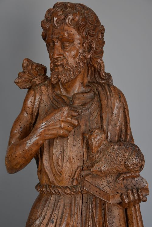 fig 2. A 16th-century carved limewood figure of St. John the Baptist holding a lamb, mounted on a dark wooden base.