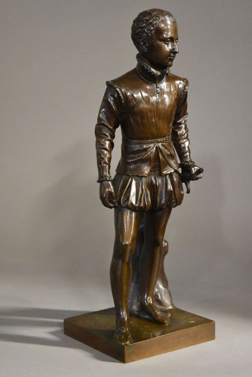fig 2. A dark brown patinated bronze standing figure of young Henry IV of France dressed in detailed Renaissance attire atop a square plinth.