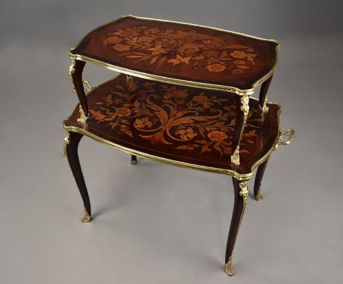 fig 2. A two-tiered French style dark wood etagere featuring elaborate floral marquetry inlays, curved cabriole legs, and ornate gilt-bronze mounts along the rims and feet.