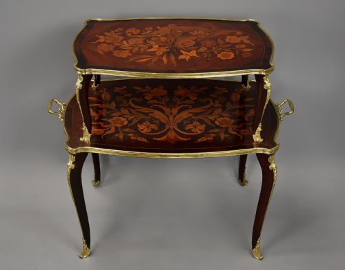 fig 3. A two-tiered French style dark wood etagere featuring elaborate floral marquetry inlays, curved cabriole legs, and ornate gilt-bronze mounts along the rims and feet.