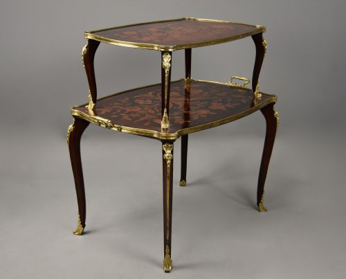 fig 4. A two-tiered French style dark wood etagere featuring elaborate floral marquetry inlays, curved cabriole legs, and ornate gilt-bronze mounts along the rims and feet.