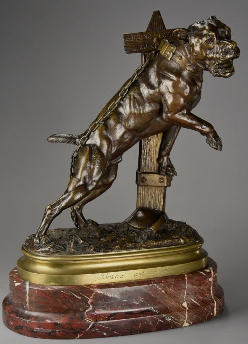 fig 1. A 19th-century dark bronze sculpture of a chained guard dog rearing against a post, mounted on a brass collar and red veined marble base.