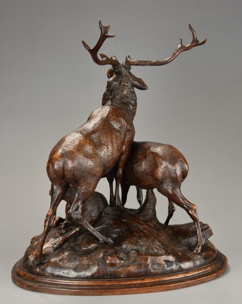 fig 5. A late 19th-century dark carved linden wood sculpture depicting a roaring stag standing above a doe and lying fawn on a naturalistic base.