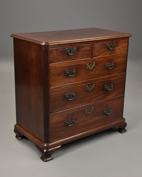 fig 1. A mid-18th century George III mahogany chest of drawers featuring a two short over three long drawer configuration with brass swan-neck handles and bracket feet.