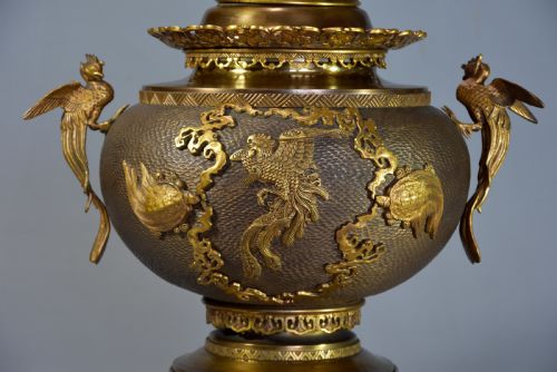 fig 2. A late nineteenth-century three-piece French Japonisme bronze garniture set featuring a central incense burner flanked by two tall urns, decorated with gilt dragon reliefs and supported on elephant head feet.