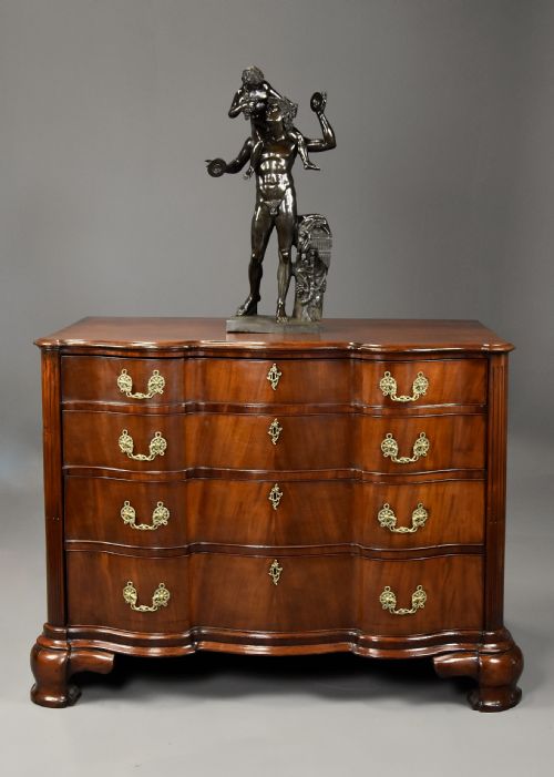 fig 1. An 18th-century mahogany oxbow commode with four drawers, ornate brass bail handles, and prominent shaped feet.