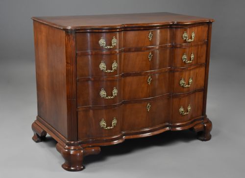 fig 2. An 18th-century mahogany oxbow commode with four drawers, ornate brass bail handles, and prominent shaped feet.