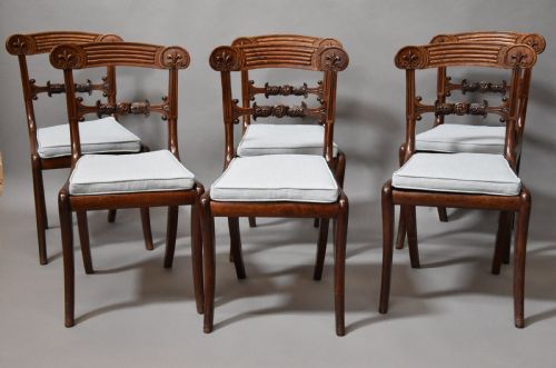 fig 1. A set of eight antique Regency mahogany dining chairs featuring reeded top rails, carved mid-rails, scrolled armrests, and pale blue upholstered seats.