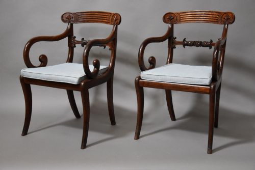 fig 2. A set of eight antique Regency mahogany dining chairs featuring reeded top rails, carved mid-rails, scrolled armrests, and pale blue upholstered seats.