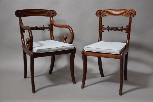 fig 3. A set of eight antique Regency mahogany dining chairs featuring reeded top rails, carved mid-rails, scrolled armrests, and pale blue upholstered seats.