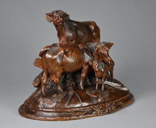 fig 1. A late nineteenth-century dark linden wood sculpture depicting a bull, cow, and calf standing on a naturalistic base with carved edelweiss motifs.