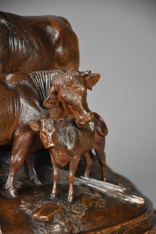 fig 3. A late nineteenth-century dark linden wood sculpture depicting a bull, cow, and calf standing on a naturalistic base with carved edelweiss motifs.