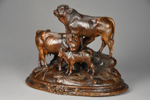 fig 4. A late nineteenth-century dark linden wood sculpture depicting a bull, cow, and calf standing on a naturalistic base with carved edelweiss motifs.