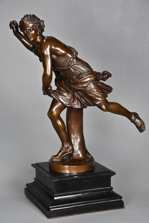 fig 4. A late 19th-century patinated bronze figure of Hippomenes in dynamic athletic posture mounted on a dark stepped plinth.