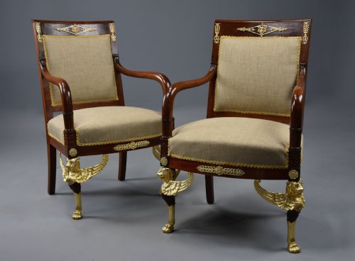 fig 3. A pair of late nineteenth-century French mahogany open armchairs featuring gilded winged lion front legs and neutral fabric upholstery.