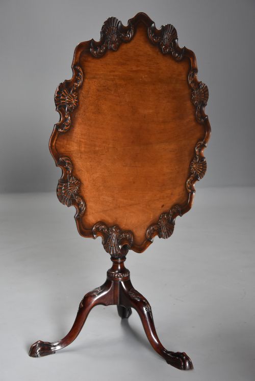 fig 2. A late 19th-century mahogany tilt-top table featuring a raised piecrust rim with carved shell details and a tripod base with claw-and-ball feet.