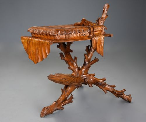 fig 2. A late nineteenth-century Italian carved pine grotto work table featuring tree-branch legs, a shell shelf, and a top detailed as a cushion with draped cloth.