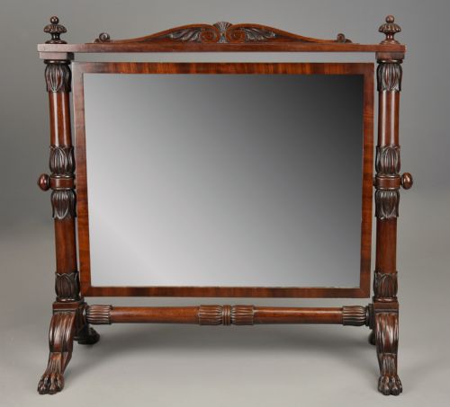 fig 1. A Regency Cuban mahogany dressing table mirror featuring a carved top cresting, reeded side columns with finials, and carved paw feet.