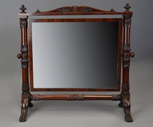 fig 2. A Regency Cuban mahogany dressing table mirror featuring a carved top cresting, reeded side columns with finials, and carved paw feet.