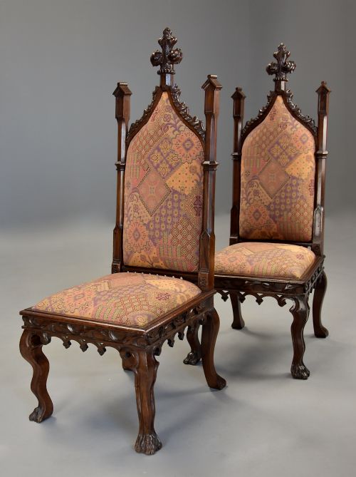 fig 3. A pair of 19th-century rosewood Gothic Revival hall chairs featuring high pointed-arch backs with carved finials and patterned fabric upholstery.