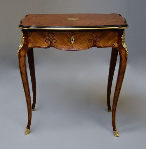 fig 1. A 19th-century French kingwood occasional table featuring cabriole legs, marquetry inlay, serpentine top, and gilt-bronze ormolu mounts.