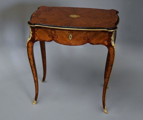 fig 2. A 19th-century French kingwood occasional table featuring cabriole legs, marquetry inlay, serpentine top, and gilt-bronze ormolu mounts.