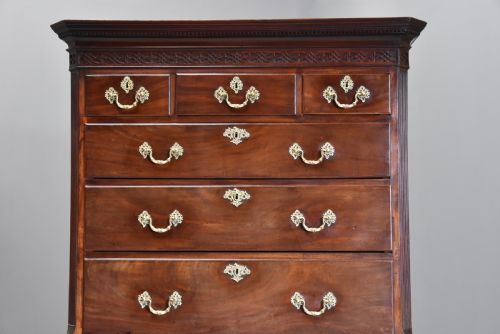 fig 3. A mid-18th-century Georgian mahogany chest on chest featuring brass drop handles, fluted pilasters, bracket feet, and multiple graduated drawers.