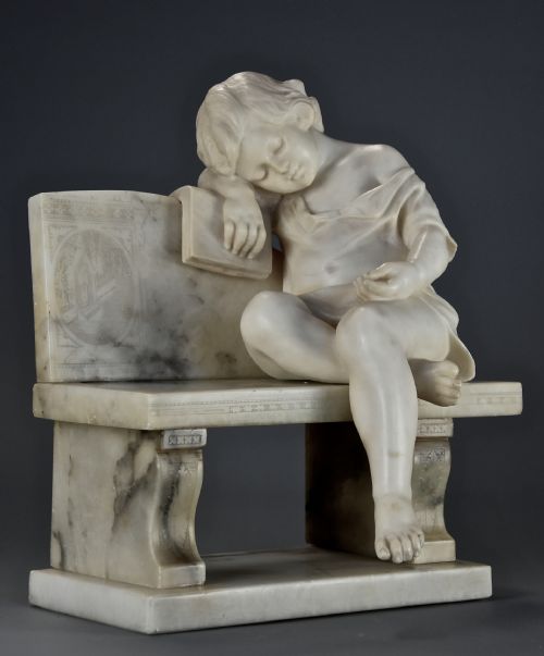 fig 2. A late 19th-century carved alabaster sculpture depicting a sleeping child seated on a bench and resting against a book.