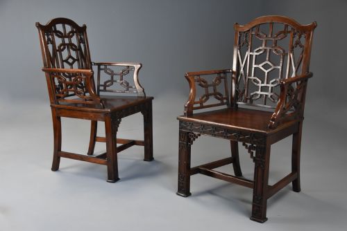 fig 1. A pair of 18th-century mahogany open armchairs featuring intricate geometric Chinese lattice backrests, fretted arm supports, and carved straight legs.