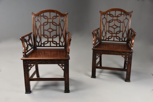 fig 2. A pair of 18th-century mahogany open armchairs featuring intricate geometric Chinese lattice backrests, fretted arm supports, and carved straight legs.