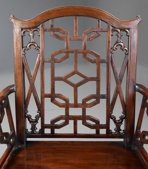 fig 5. A pair of 18th-century mahogany open armchairs featuring intricate geometric Chinese lattice backrests, fretted arm supports, and carved straight legs.