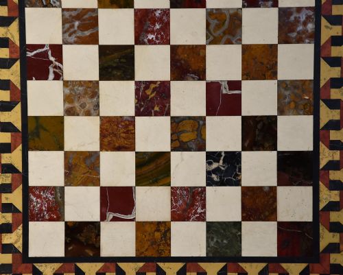 fig 4. A mid-19th century rosewood games table featuring a square specimen marble inlaid chessboard top resting on a carved pedestal stem and scroll feet.