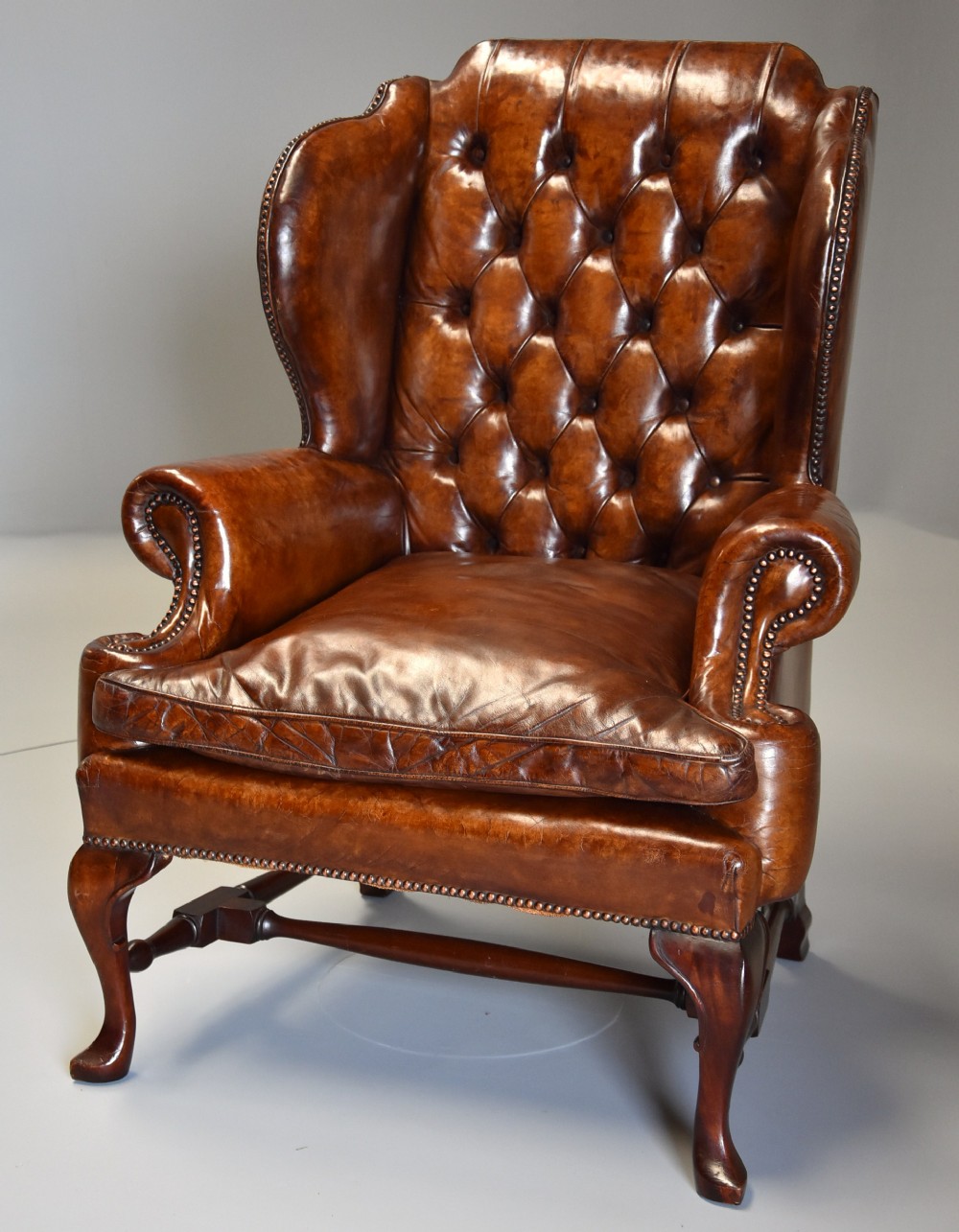 Early 20th century Georgian style deep buttoned brown leather wing armchair