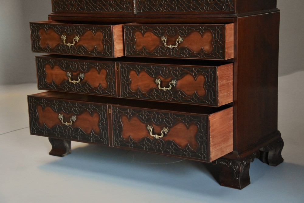 A mid-nineteenth century mahogany press cupboard featuring carved double doors with flame mahogany panels over a base of carved drawers with brass handles. View XI