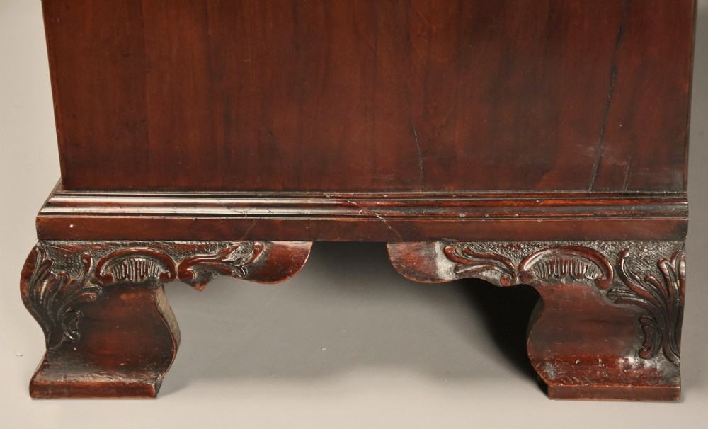 A mid-nineteenth century mahogany press cupboard featuring carved double doors with flame mahogany panels over a base of carved drawers with brass handles. View XIII