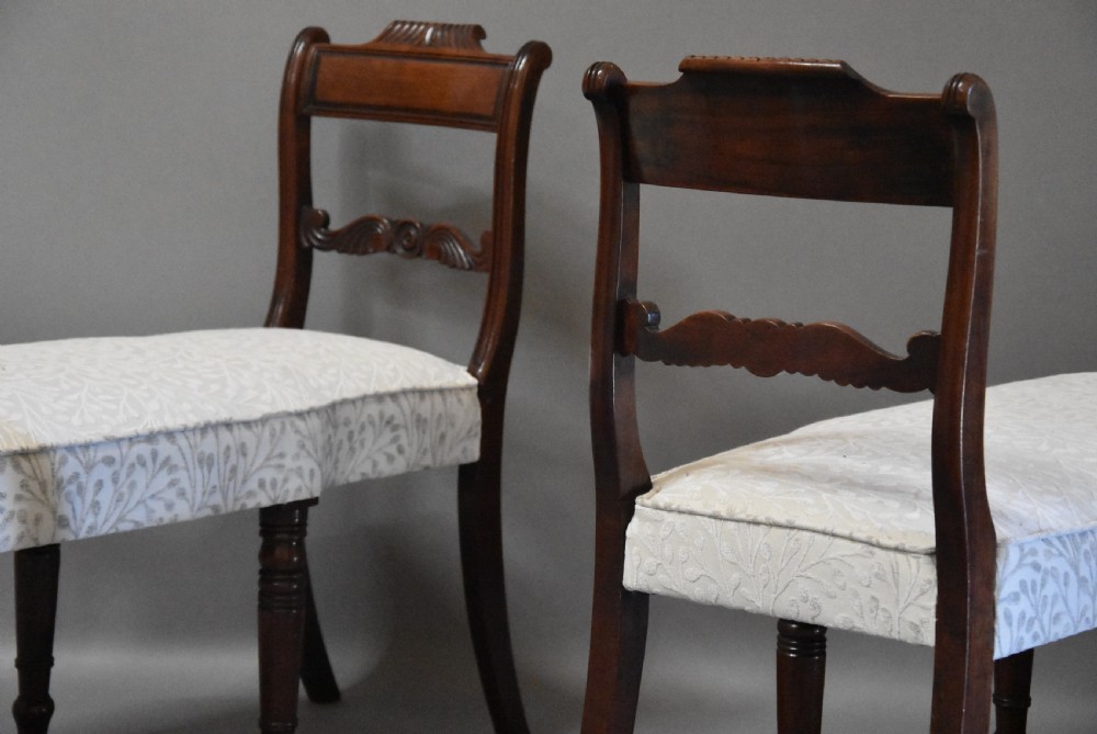 A pair of early nineteenth-century mahogany window seats with carved backrails at each end, turned legs, and cream fabric seats. View VII