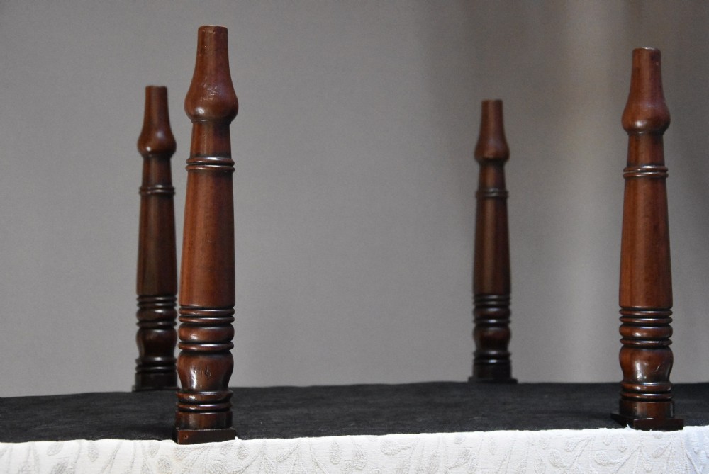 A pair of early nineteenth-century mahogany window seats with carved backrails at each end, turned legs, and cream fabric seats. View XI