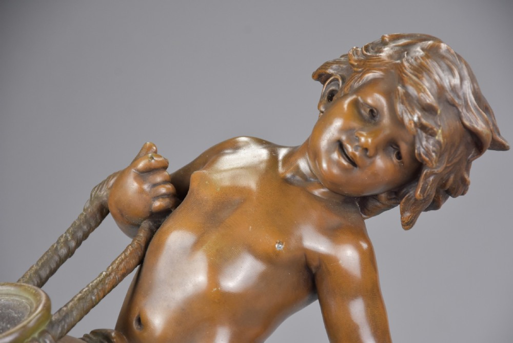 Late 19th-century French bronzed spelter figure depicting a young male water carrier holding a jug over his shoulder on a naturalistic base. View III