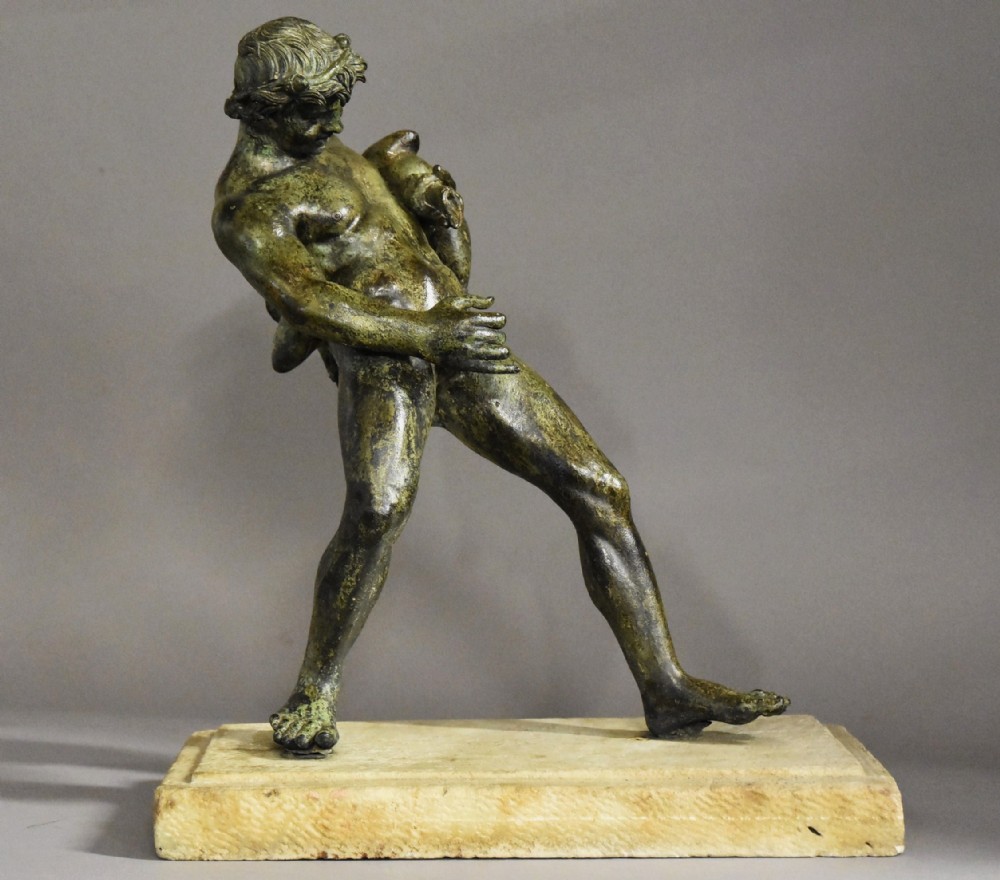 A late 19th-century green patinated bronze figure of Bacchus mounted on a rectangular stone plinth.