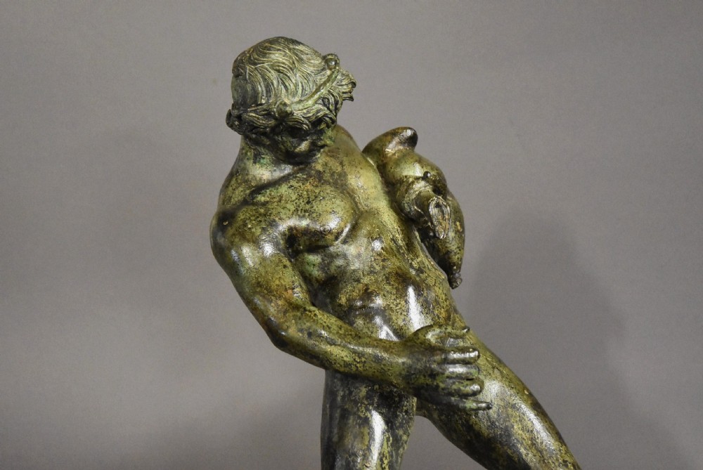 A late 19th-century green patinated bronze figure of Bacchus mounted on a rectangular stone plinth. View IV