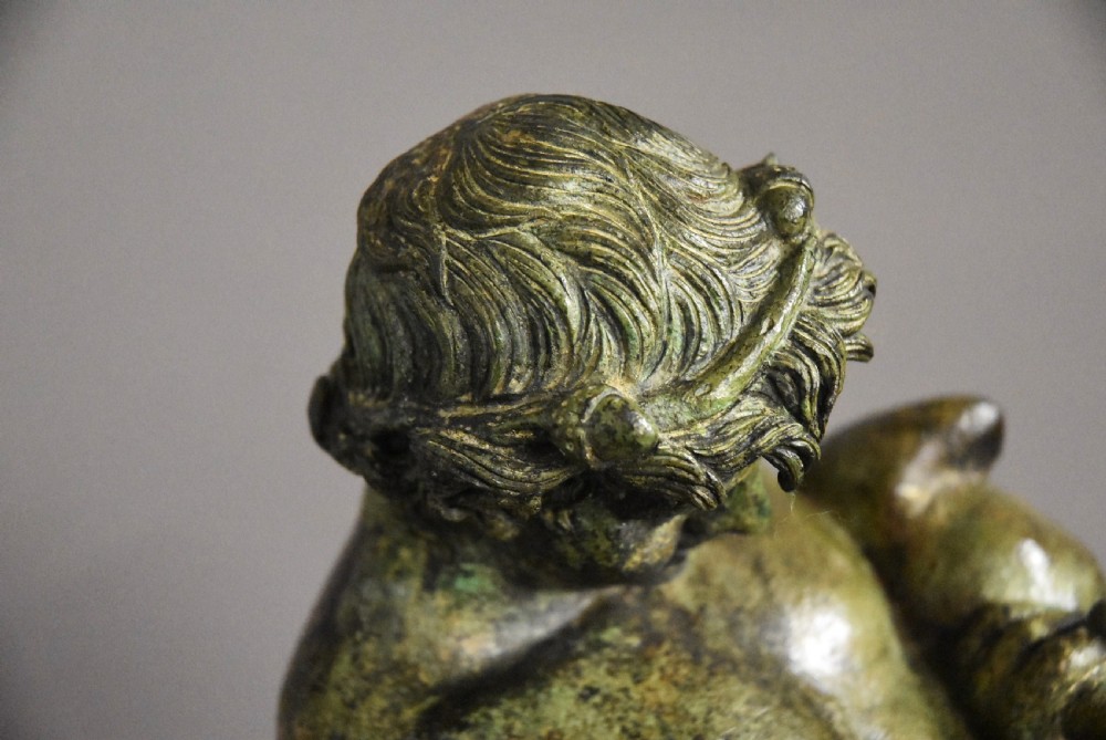 A late 19th-century green patinated bronze figure of Bacchus mounted on a rectangular stone plinth. View V