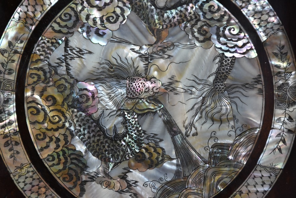 A square dark hardwood box decorated with mother-of-pearl inlay featuring a central dragon motif inside a circular frame surrounded by corner floral designs. View V