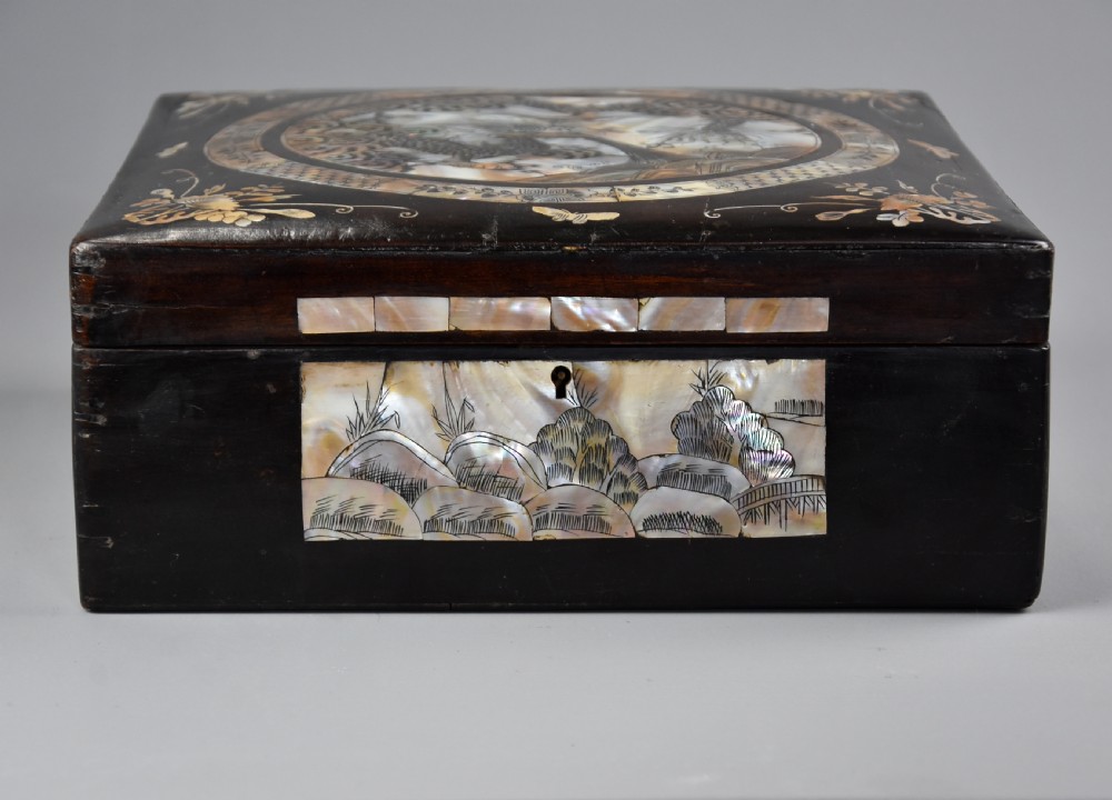 A square dark hardwood box decorated with mother-of-pearl inlay featuring a central dragon motif inside a circular frame surrounded by corner floral designs. View VI