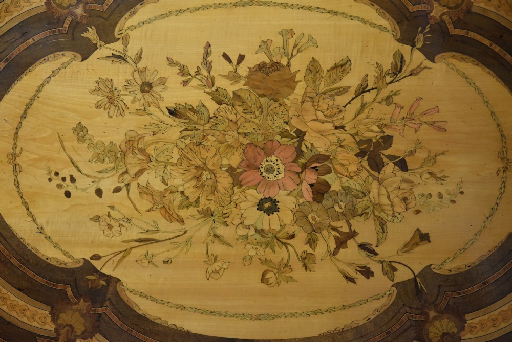 An oval mid-19th century sycamore centre table featuring intricate floral marquetry, ormolu trim, and a turned pedestal with four swept legs. View IX