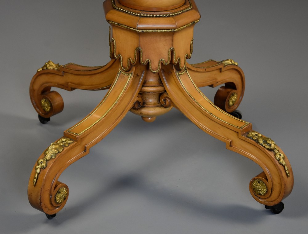 An oval mid-19th century sycamore centre table featuring intricate floral marquetry, ormolu trim, and a turned pedestal with four swept legs. View XIV
