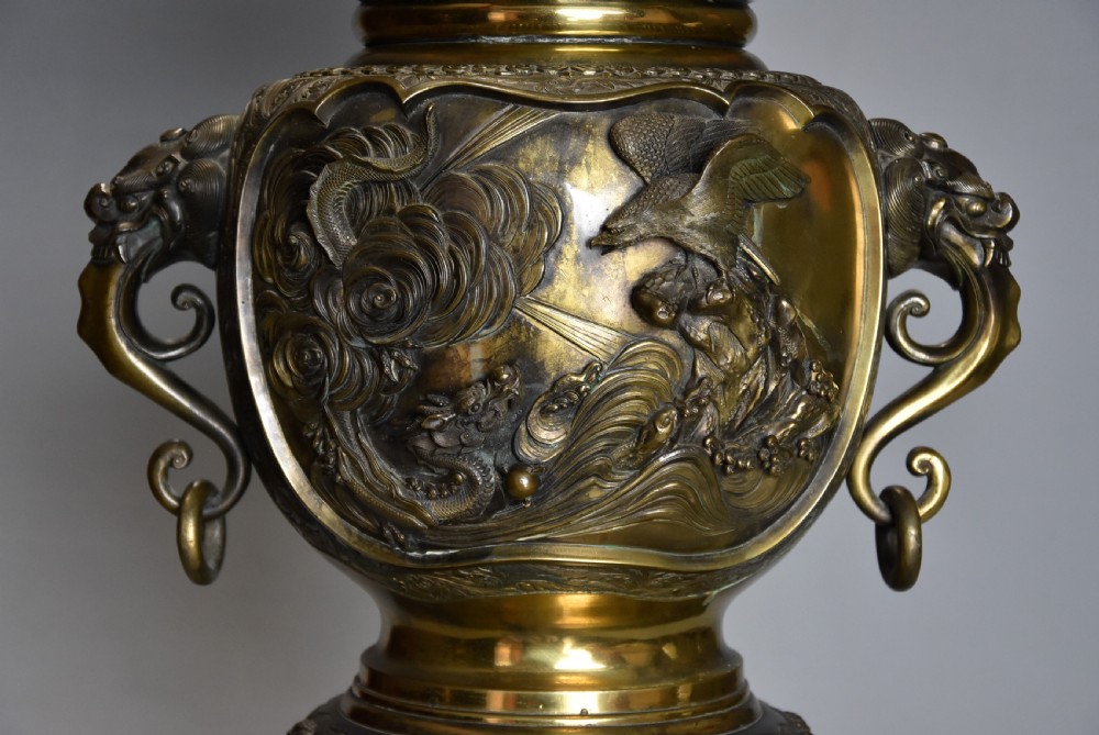 A large 19th-century Japanese Meiji period patinated bronze vase with relief carvings of birds, dragon head handles, and decorative patterned borders. View III