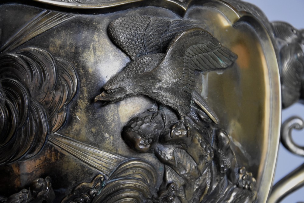 A large 19th-century Japanese Meiji period patinated bronze vase with relief carvings of birds, dragon head handles, and decorative patterned borders. View IV
